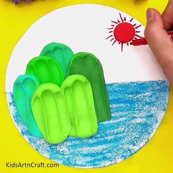 Drawing sun rays with red marker- Simple Art Projects for Kids Featuring Mountain and Sea Scenery 