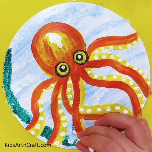 Make A Green Pattern Around The Octopus Using A Cotton Bud And Green Paint-