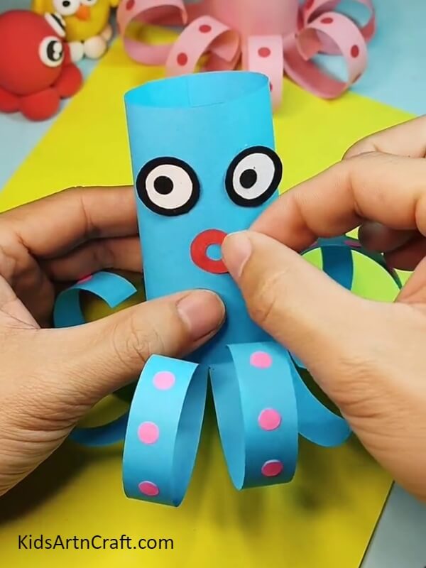 Pasting the mouth on the octopus- A straightforward tutorial on creating a paper octopus with kids. 