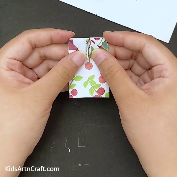 Making small folds at the top- Crafting a paper bow with origami for kids