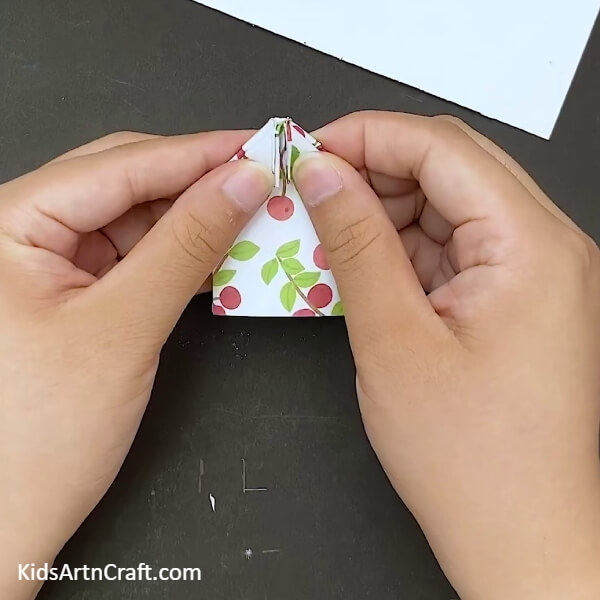 Repeating the process on the side below- A guide to creating an origami paper bow for children