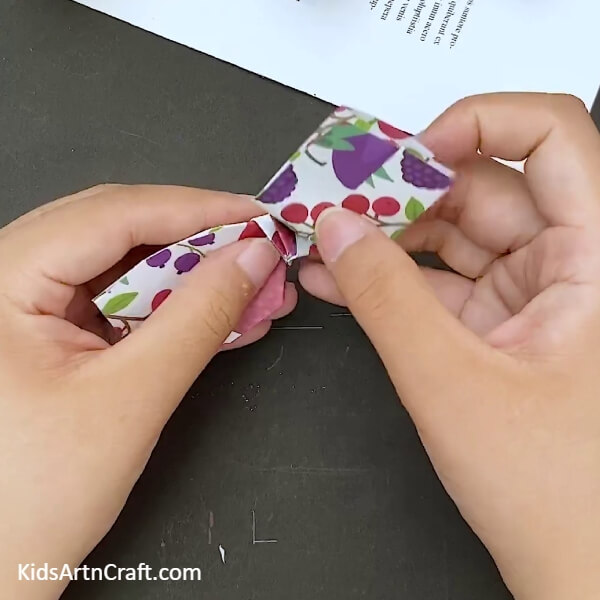 Opening the fold in the middle- Tutorial for a paper bow with origami for little ones