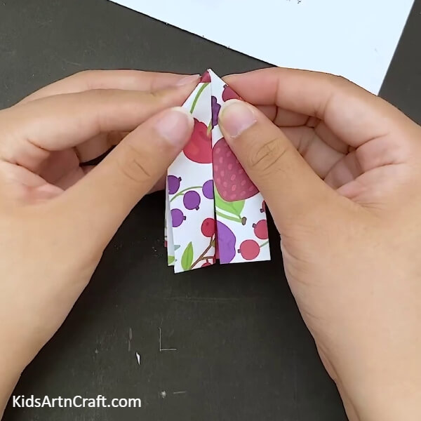 Repeating the process on the other side as well- Paper bow crafting with origami for kids