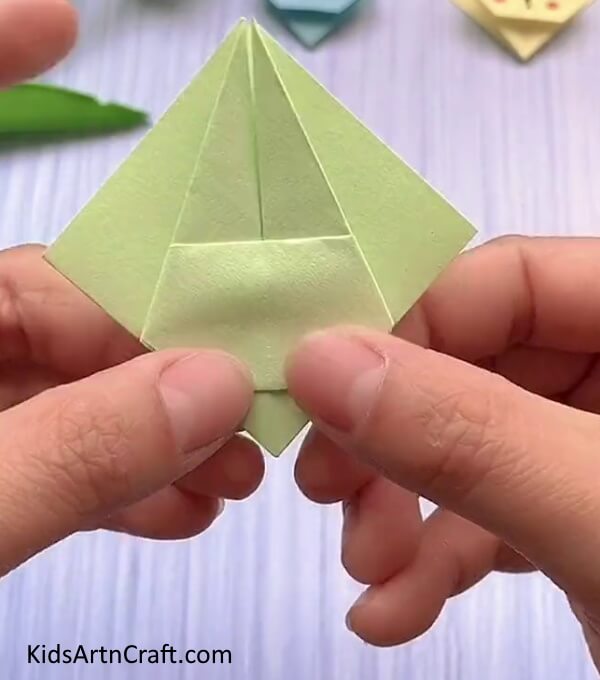 Folding The Bottom Corner Inside- This is a simple step-by-step guide to making a cute rabbit face with origami for children. 