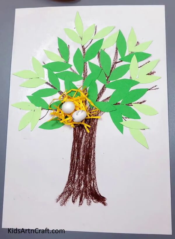 Pasting Eggs On Nest - An uncomplicated paper tree with a birds nest made especially for kids.