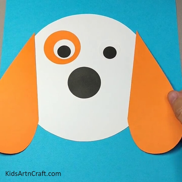 Sticking the ears of the dog- An Easy Step-by-Step Guide to Making a Dog Face Out of Paper for Children