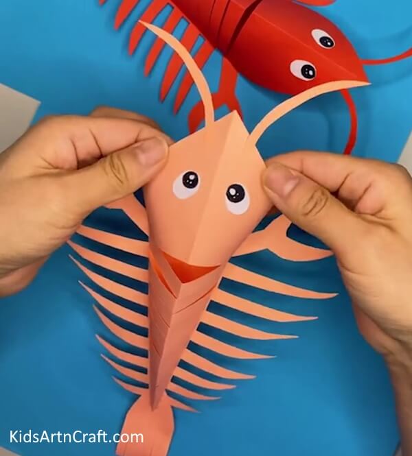 Pasting the Eyes of the Lobster- Tips for Crafting a Lobster with Paper for Kids 