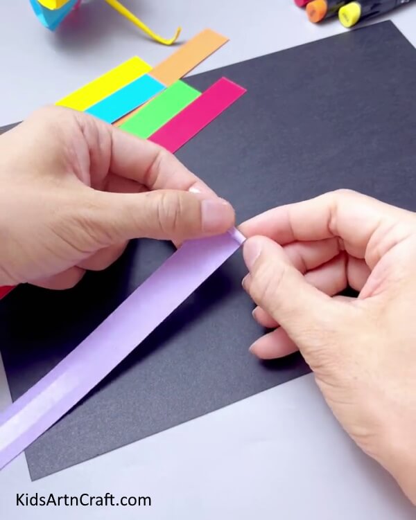 Wrapping A Paper Strip Around Ear Bud - Constructing a paper-based spinning toy craft for kids can be a blast.