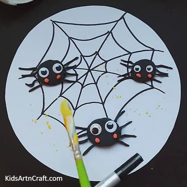 Sprinkle yellow poster on white paper-making an cute spider craft for children