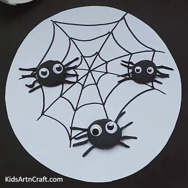 Stick googly eyes on spider-Step-by-step guide to make Spider Web Craft for kids