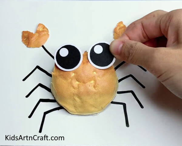 Pasting The Eyes Of The Crab-Follow These Tips To Make A DIY Crab Creation With Your Toddler