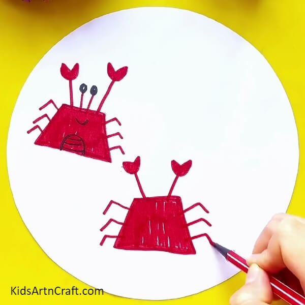 Making legs of the crab with red sketch pen- A Step-by-Step Guide to Drawing a Crab with a Sketch Pen 