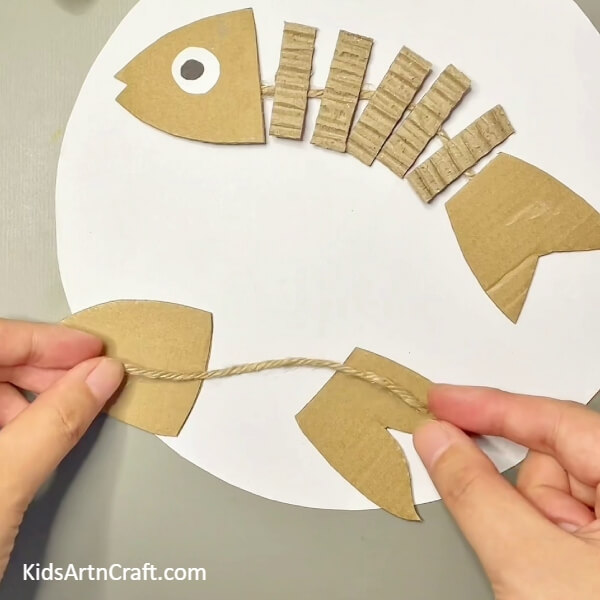 Joining The Head And Tail With A Jute Thread - Putting Together a Fish Craft Using Cardboard, Piece of Cake 