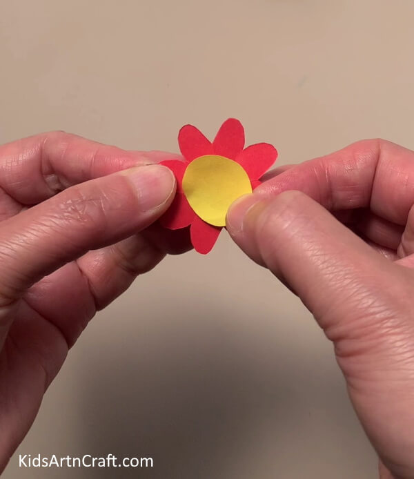 Pasting A Yellow Circle on The Red flower -Marvelous Flower Paper Rings Jewelry Art For Little Ones To Create At Home