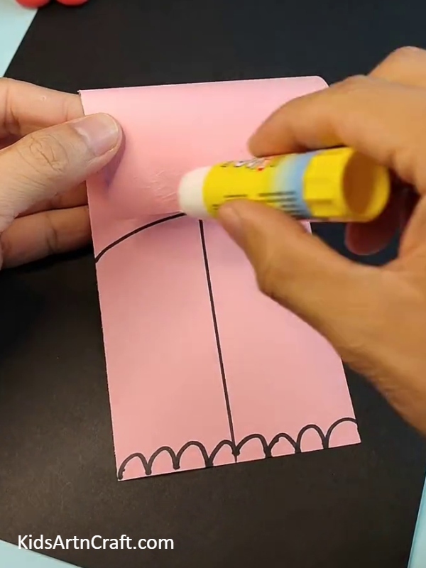 Applying glue on pink paper- Crafting Elephant Art From Paper Quickly For Kids 