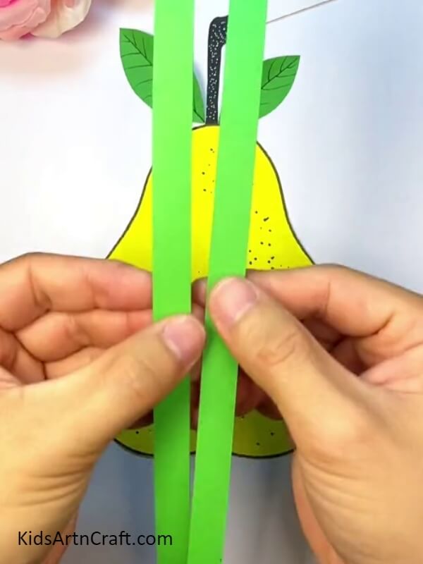 Take Two Vertical Strips Of Green Craft Paper To Make Worms - Making a Pear-Fruit Worm With Kids - A Quick Tutorial 