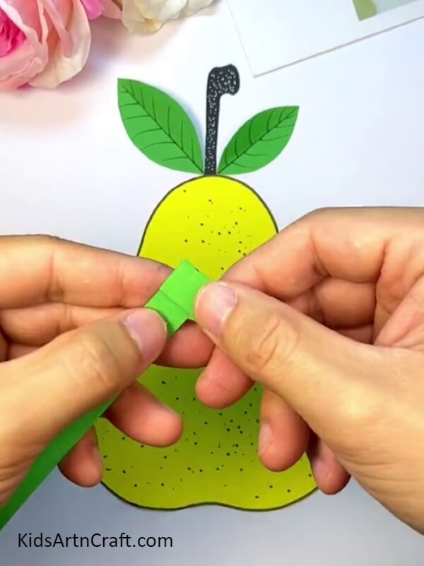 Start Folding The Vertical Strip Of Paper To Make Worms - A Quick Guide to Crafting a Pear-Fruit Worm With Kids