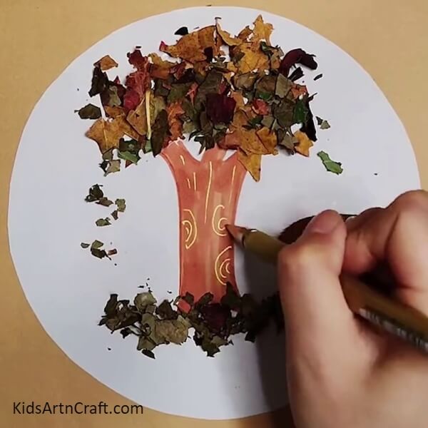 Adding Shimmer with a Golden Glitter Pen- Instructional Guide on Constructing a Tree Out of Leaves From the Fall 