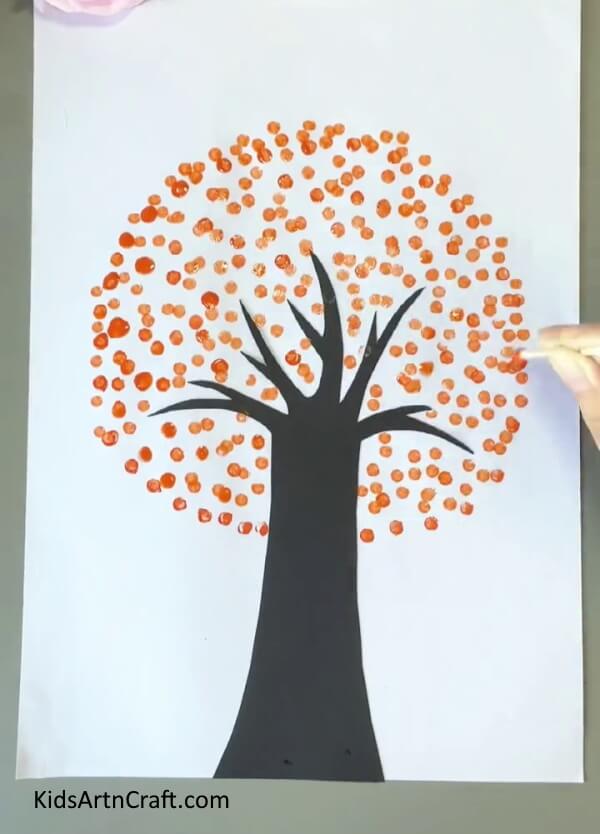 Completing Making Orange Leaves-Creating a tree painting with earbuds is an easy task for children