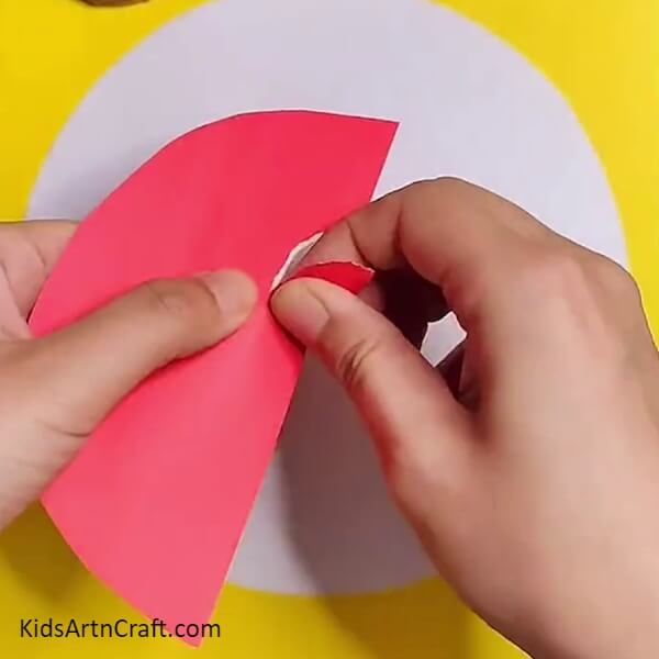Cutting red color paper using scissors- Crafting with Watermelon Ants – A Fun Activity for Little Ones