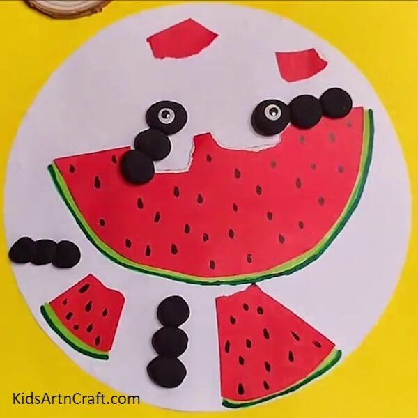 Pasting doll eyes for ants- Trying Creative Art with Watermelon Ants – A Kid-Friendly Idea