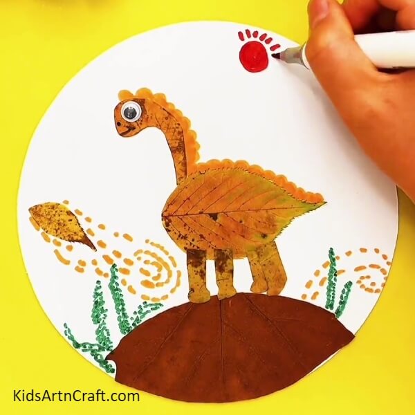 Make sun with the red marker/sketch pen- Teaching Kids to Craft a Dinosaur Landscape with Fall Leaves