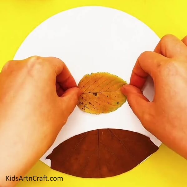 Take a yellow leaf- How to Make a Dinosaur Scene with Fallen Leaves for Kids