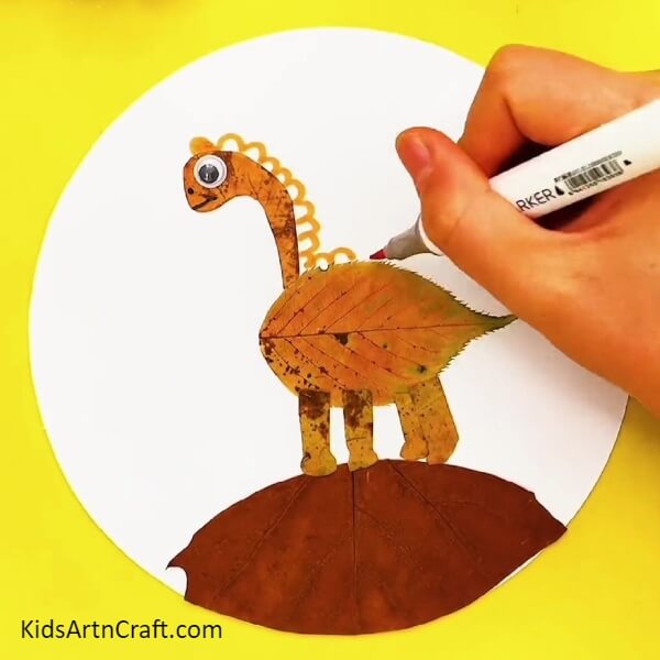 Make features of the dinosaur- Teach Kids to Make a Dinosaur Scene with Fallen Leaves