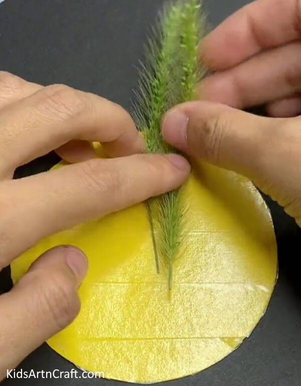 Sticking A Green Wheat Strand- Crafting a Lion of Wheat and Paper for Kids