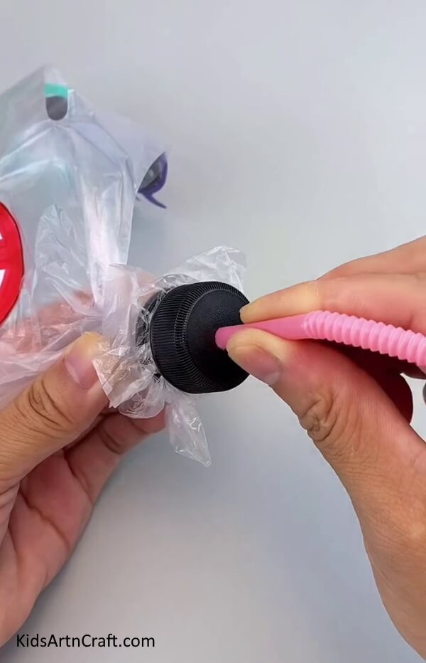 Insert The Foldable Straw Through a Recycled Plastic Bottle Cap-How to Create a Plaything from Recycled Supplies for Children