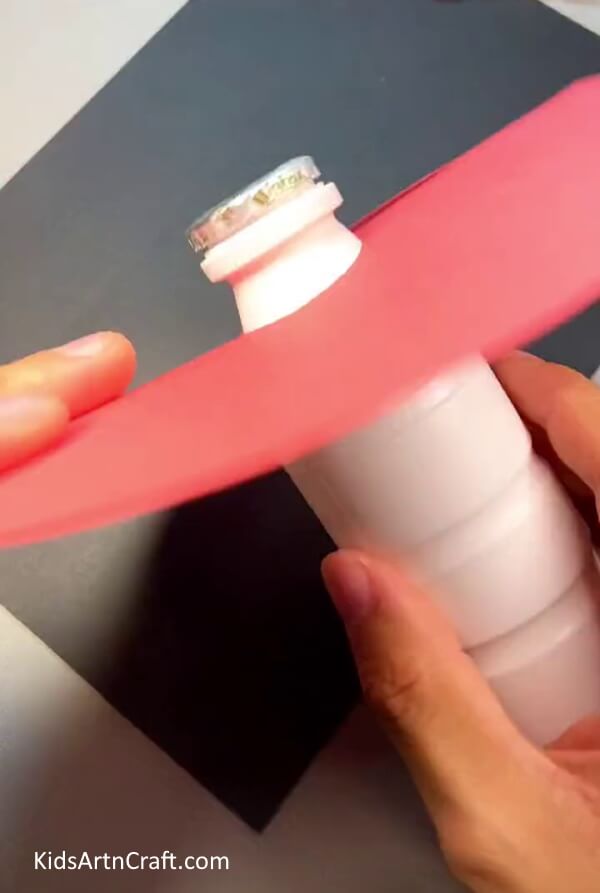 Placing The Plastic Bottle In A Small Hole On A Red Circle To Make The Mushroom's Head - Assembling a 3D Mushroom with paper and a plastic bottle