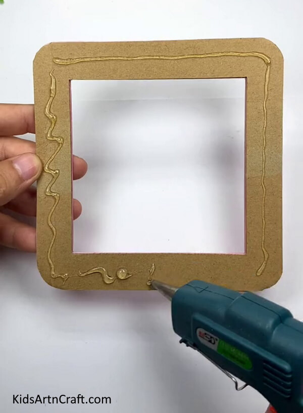 Apply Glue Gun On The Frame-Making a cardboard jigsaw in the residence