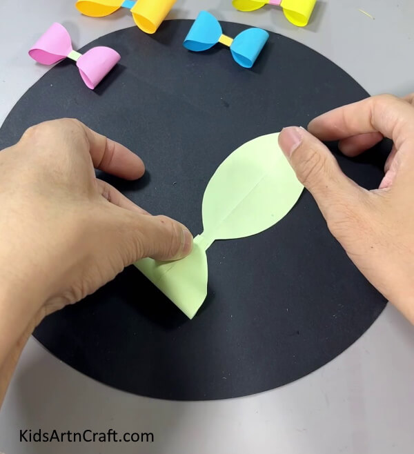 Folding Left Side To the Middle - Make a paper bow with this easy-to-follow tutorial for kids.