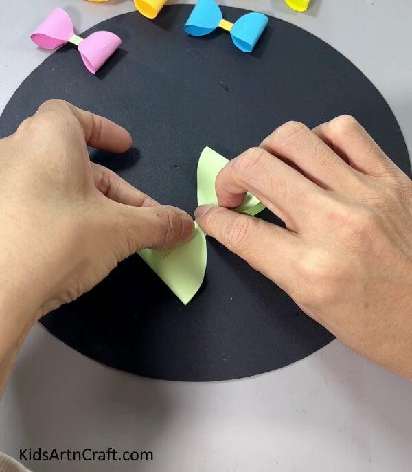 Folding the Right Side To the Middle - This tutorial will show kids how to assemble a paper bow in no time.