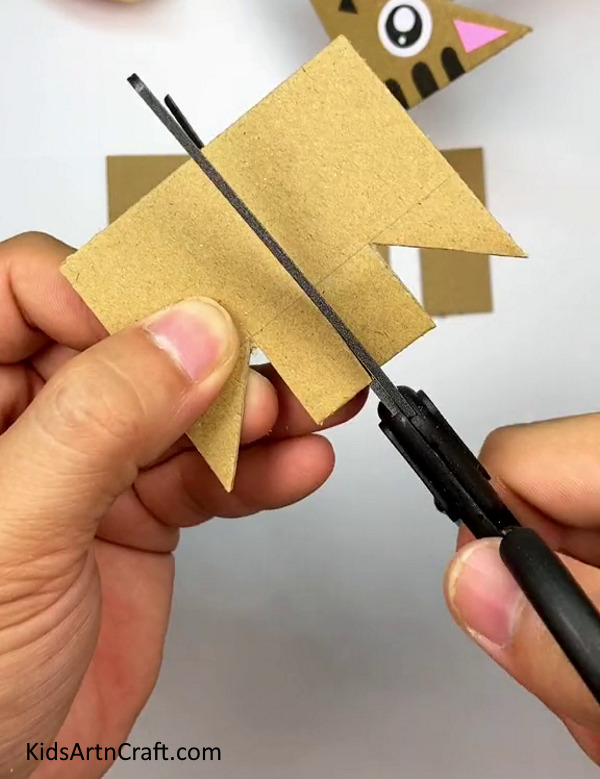 Making A Cut In The Center Till The Drawn Line-Follow this simple tutorial for kids to create a Cardboard Cat 