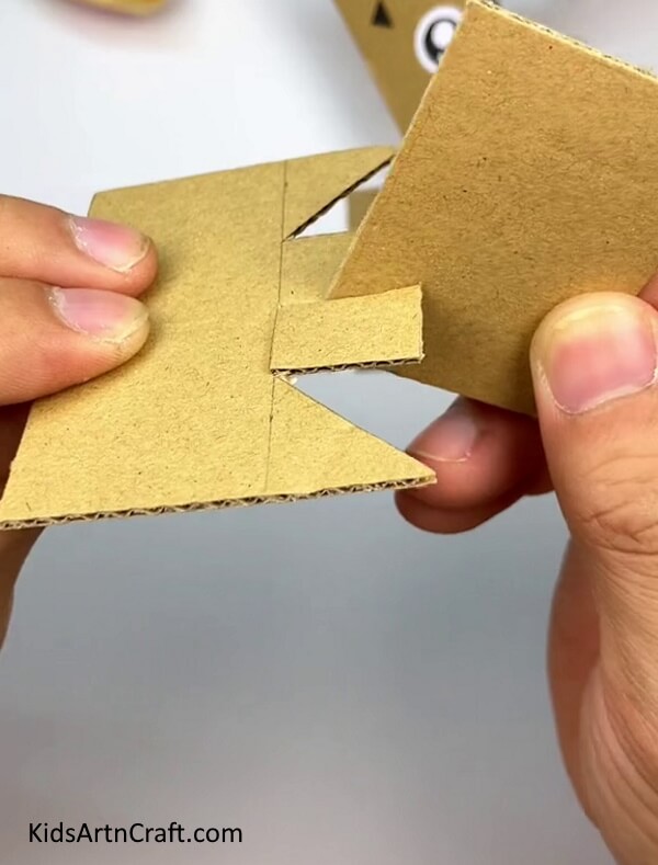 Placing The Other Rectangle In The Cut-This guide offers a straightforward tutorial for kids to make a Cardboard Cat 