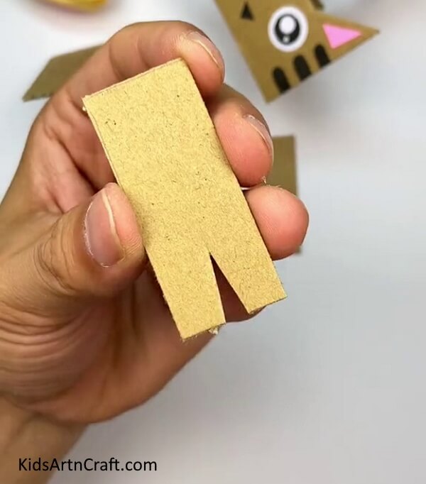 Making A Triangular Cut In The Thick Rectangular Cardboard Strip-Make a Cardboard Cat using this simple tutorial for children 