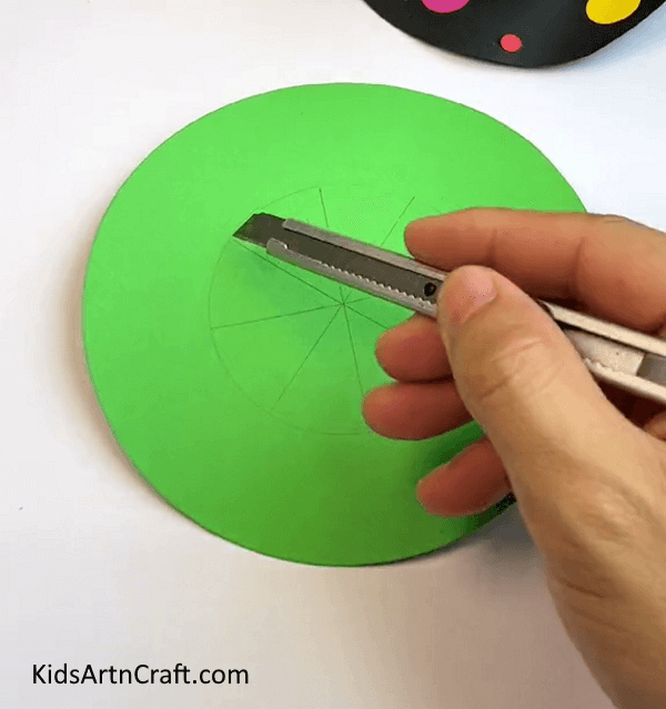Take Circular Green Paper And Draw A Circle Along With Lines With The Paper Cutter-How to make Mini Paper Cup Hat For Kids