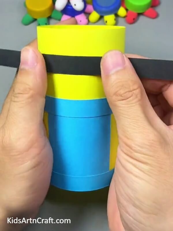 Glue A Black Strip On Top-middle Of The Bottle to make a Minion Pencil Stand- Kids can make their own Minion pencil holder with this tutorial 