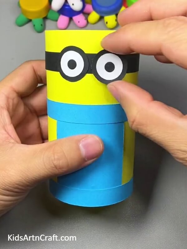 Create Minion Eye Using Black Marker On White Craft Paper to creating a Minion Pencil Stand- Making a Minion pencil holder - a tutorial for young crafters 