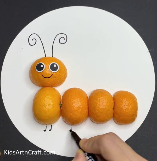 Drawing Antennas And Legs - Forming a Gorgeous Caterpillar Artwork from Orange Peels with Toddlers