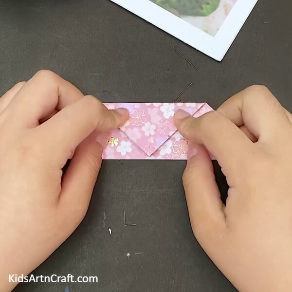 Making A Fold On The Top Corner Of The Triangle- Creating a heart-shaped envelope with the art of origami 