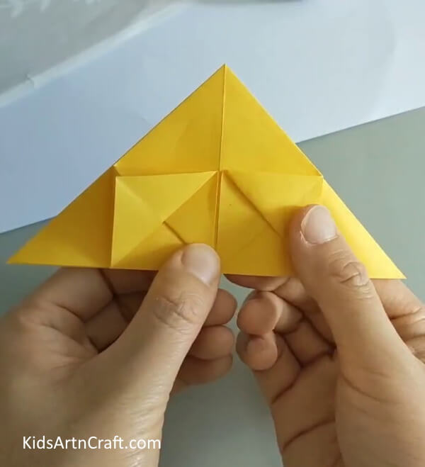 Fold the design upwards, creating small triangles- How to Construct a Rose with Origami for Newcomers