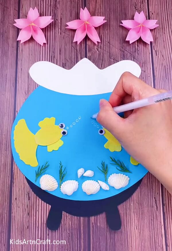 Drawing oxygen bubbles using white pen. To make an craft of aquarium for childrens