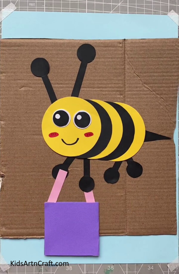 Attaching the Bucket to the Bee's Legs to look good for kids-A Paper Bee craft that children can make with ease 