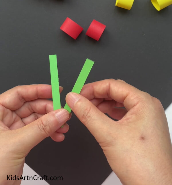 Making A V-Shape From The Green Strip A step-by-step guide for kids on crafting Paper cherries 