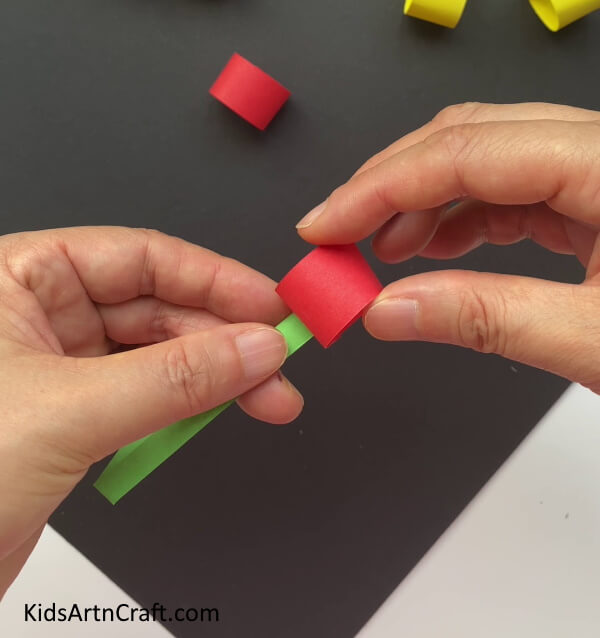 Pasting The Red Ring On The Green Strip Kids can learn to make Paper cherries with this simple tutorial 