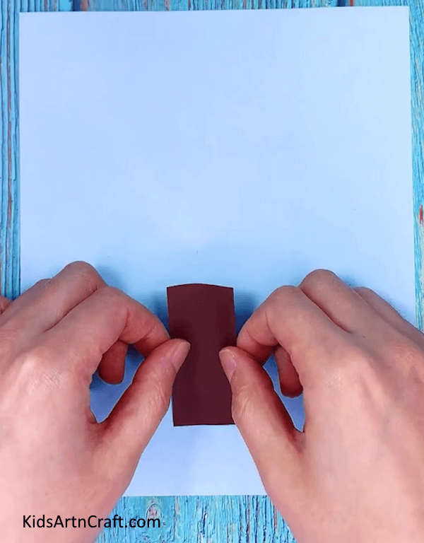 Taking blue craft paper and brown craft paper- Creating a paper Christmas tree for decoration during the holidays 
