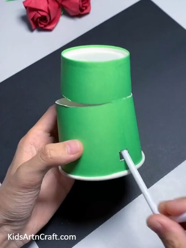 Inserting A Straw-This tutorial provides instructions for constructing a paper cup frog puppet