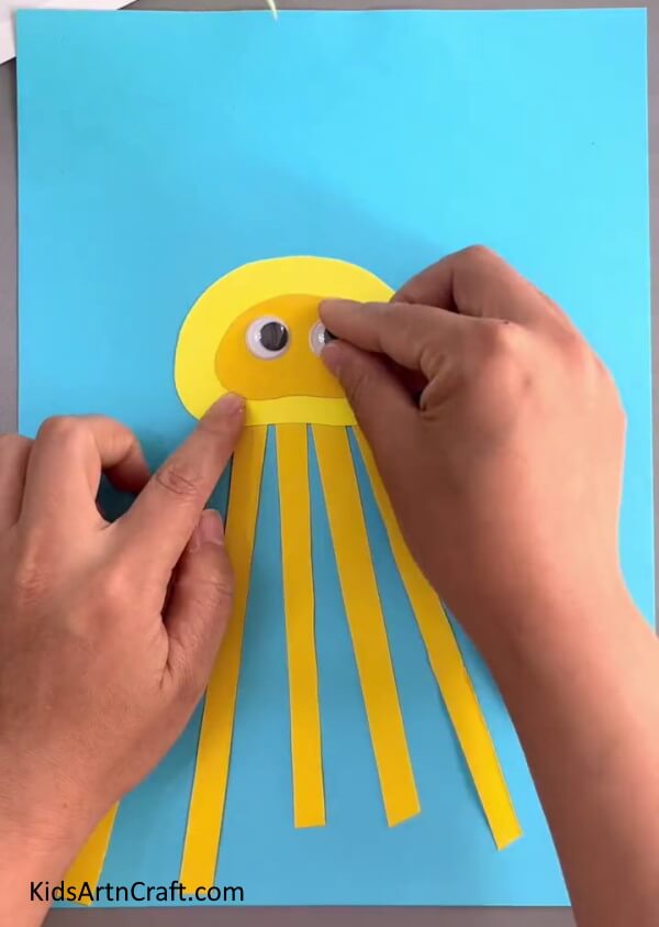 Stick The Eyes Of Octopus On The Smaller Dome- Crafting a Paper Octopus for Little Ones 